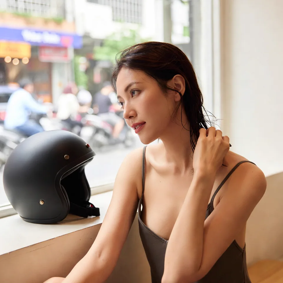 Người dùng chỉnh lại mái tóc sau khi tháo mũ bảo hiểm trong điều kiện nóng ẩm